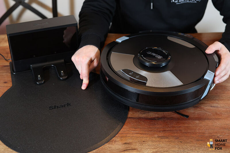 Eine einfache Ladestation eines Shark Saugroboters steht auf dem Boden.